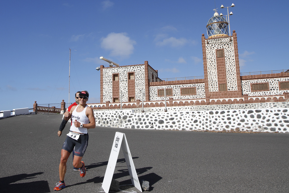 Triatleta corriendo junto al Faro de la Entallada